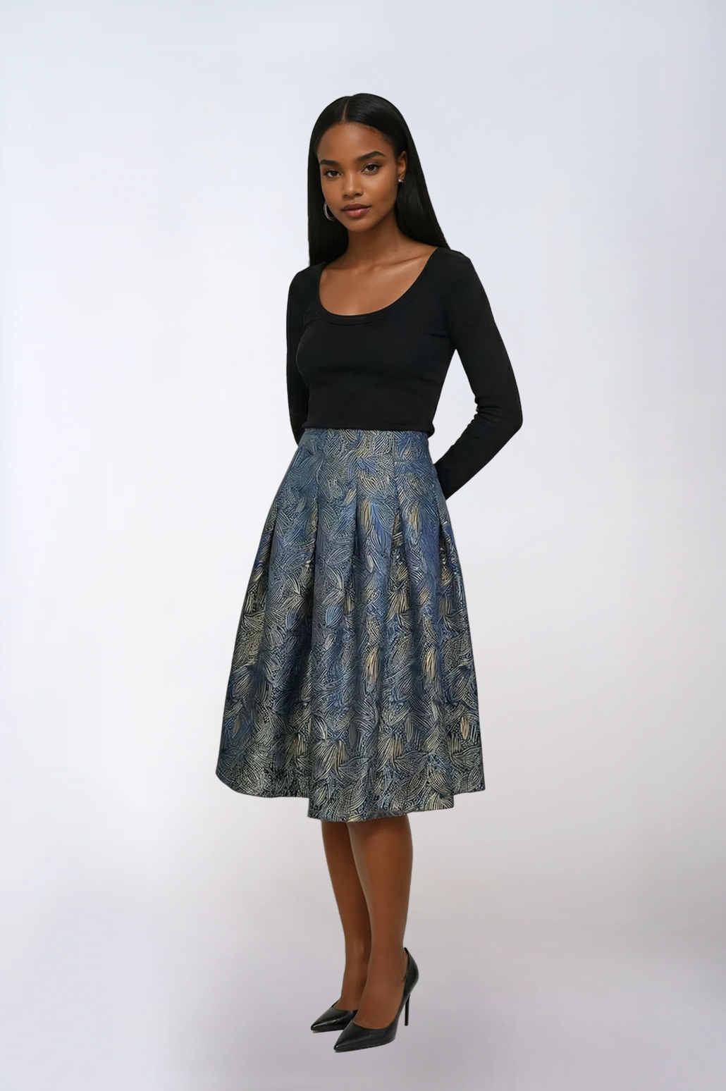 Woman wearing a black top and patterned skirt on a white background